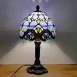 Vintage table lamp with handmade colored glass shade casting warm ambient light