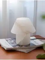 Elegant marble table lamp with soft glow on bedside table in bedroom