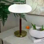 White glass table lamp with vintage design on a wooden desk in a cozy bedroom