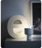 Rotating petal desk lamp with adjustable petals in pastel colors on a bedside table