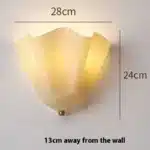 Modern wall sconce with shell-shaped glass and LED light in a minimalist living room