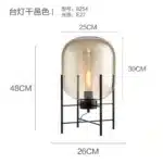 Modern floor lamp with iron frame and glass shade in a cozy living room