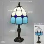 Tiffany table lamp with colorful stained glass shade casting warm glow on nightstand
