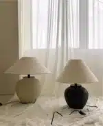 Wabi sabi table lamp with textured ceramic base and linen shade in a cozy living room