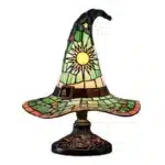 Witch hat lamp with stained glass pattern casting a warm glow on a bedside table