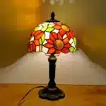 Vintage table lamp with handmade colored glass shade casting warm ambient light