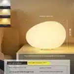 Warm night light pebble LED lamp glowing on a bedside table