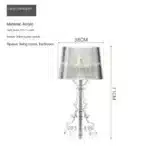 White ghost table lamp with transparent baroque design on a bedside table in a modern bedroom