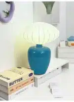 Vintage table lamp with retro ceramic base and silk shade on bedside table in cozy bedroom
