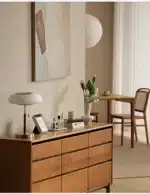 White glass table lamp with vintage design on a wooden desk in a cozy bedroom